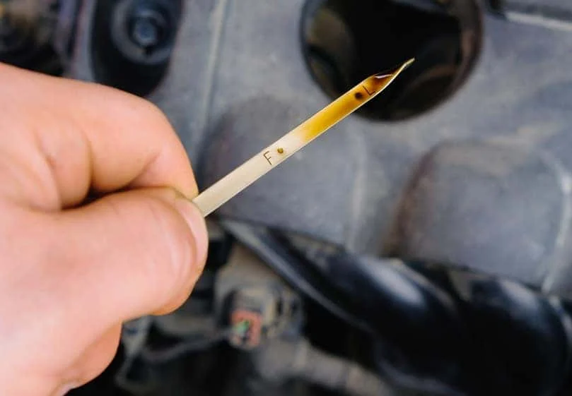 Technician checking oil level with a dipstick