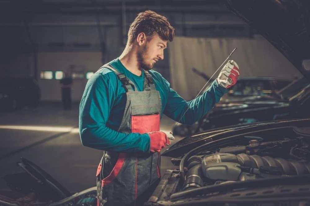 Technician checking oil level at BMW of Albany service center