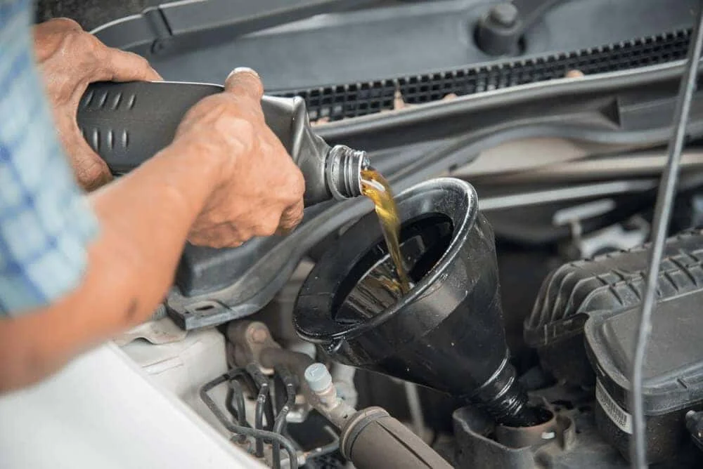 Technician pouring new engine oil into a BMW at BMW of Albany