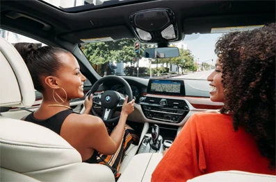 A driver and passenger laughing together while driving a vehicle