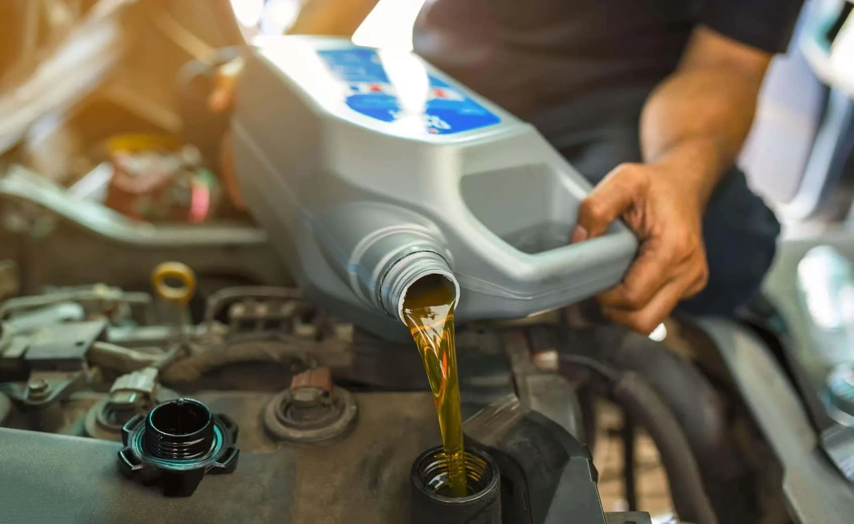 BMW technician filling an engine with new oil at BMW of Albany
